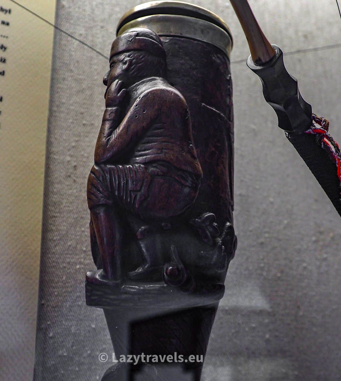 A pipe with a motif of a man shitting