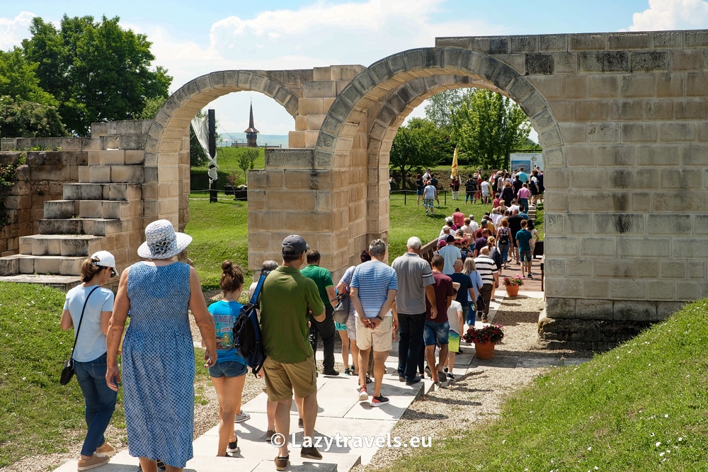 Tourists follow the reenactment, watch the cannon shot