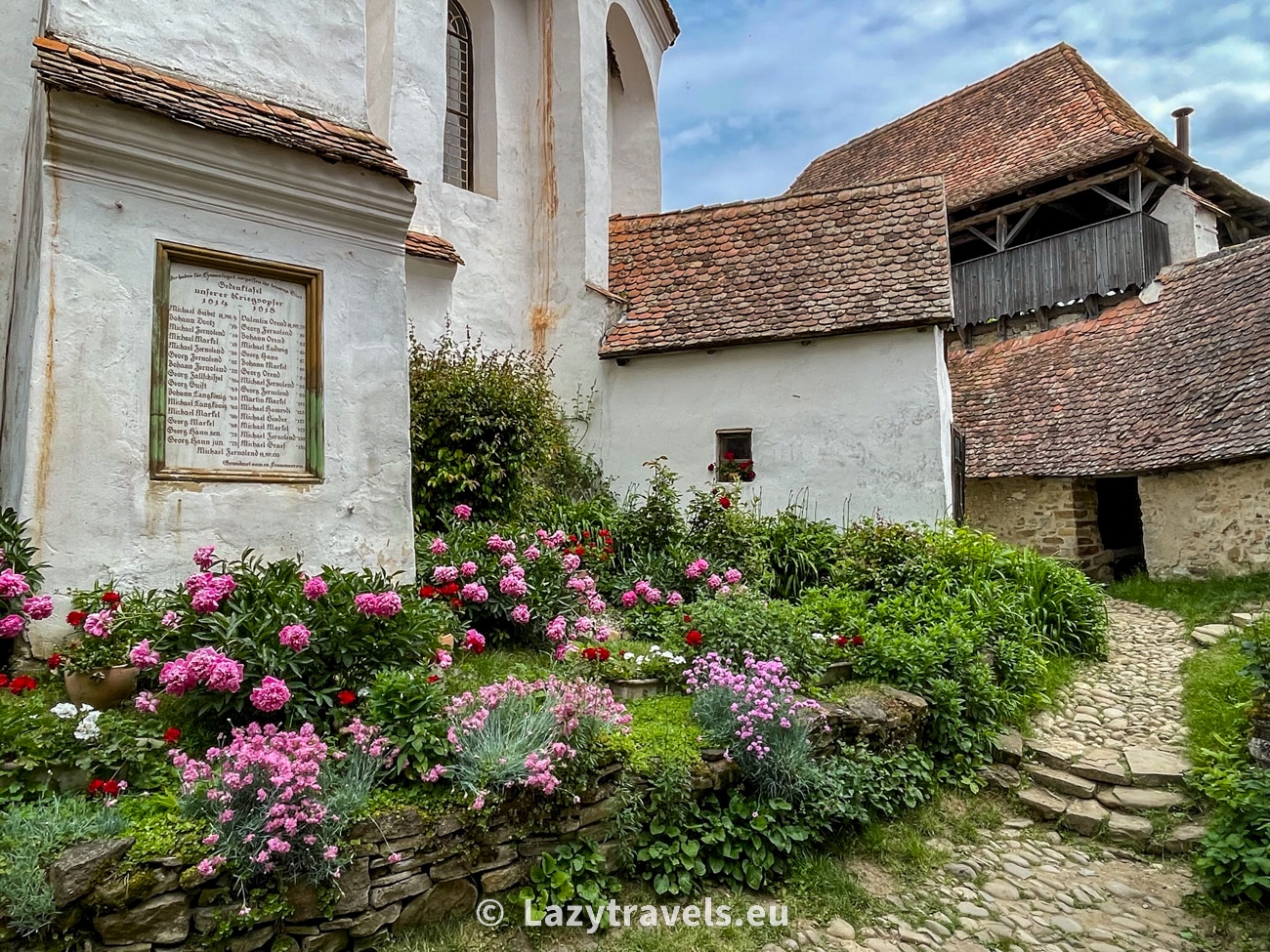 In the courtyard of the fortified church in Viscri, flower beds with flowers are a surprise.