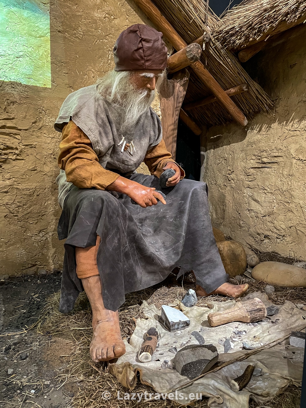 A flint knapper working on a piece of flint