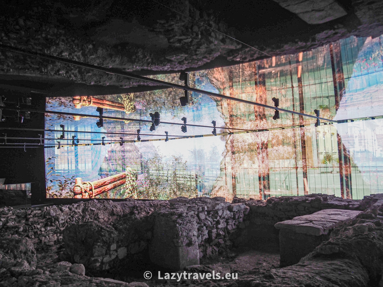 On a screen located just above the ruins of the old buildings in Wiślica, the Wiślica Museum displays interactive visualizations showing what Wiślica looked like in its heyday